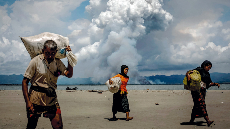 نازحون من الروهينغا يسيرون في جو ملبد بالغيوم. رويترز
