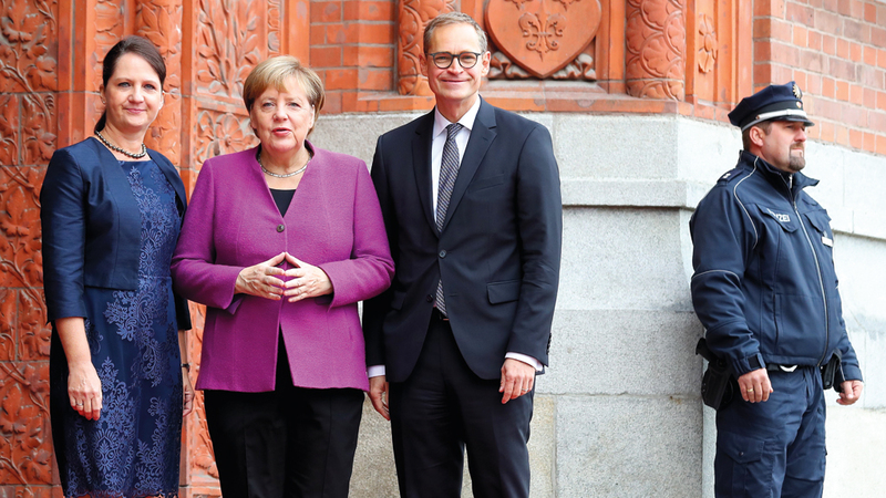 المستشارة الألمانية أنغيلا ميركل في لقطة تذكارية مع رئيس البرلمان الألماني مايكل موللر أمام مقر بلدية برلين قبل الاحتفال الرسمي بيوم الوحدة في برلين. إي.بي.إيه