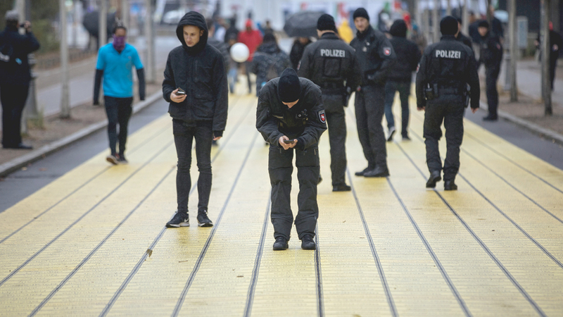 ضابط شرطة يلتقط صورة تذكارية للوحة صفراء كتبت عليها أسماء المدن والبلدات الألمانية التي رسمت بمناسبة الاحتفال بيوم وحدة ألمانيا. إي.بي.إيه