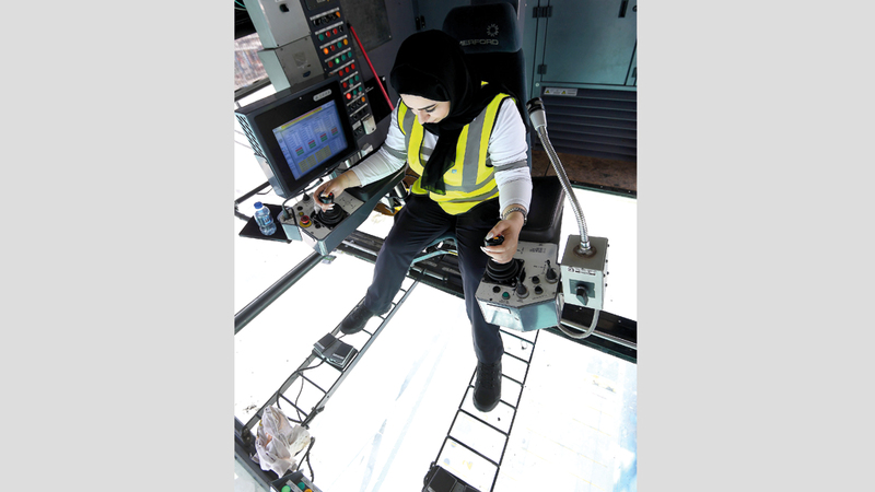 ليلى آل بشر تجلس في غرفة التحكم لتقود رافعات يقارب ارتفاعها 15 طابقاً وتحركها بكل دقة.

تصوير: إريك أرازاس