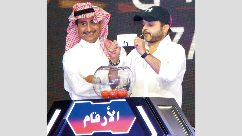 من مراسم إجراء القرعة بحضور الفنانين المصري والسعودي محمد هنيدي وناصر القصبي. من المصدر