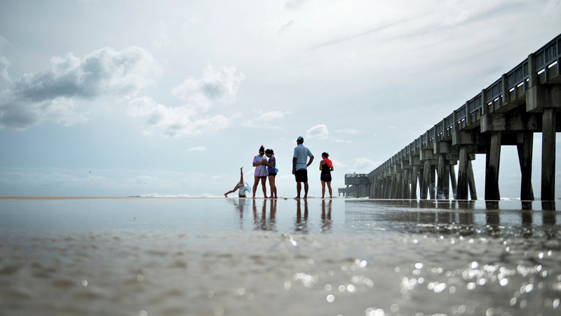 مواطنون أميركيون يقفون على شاطئ خليج المكسيك مع اقتراب الإعصار «مايكل».  أ.ف.ب