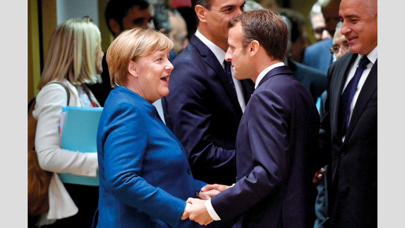 ميركل والرئيس الفرنسي خلال القمّة.  أ.ف.ب