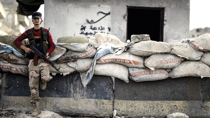 مقاتل من المعارضة السورية في إحدى نقاط التفتيش بإدلب. أ.ب