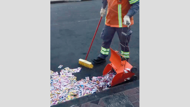 عمال بلدية دبي ينظفون الأرض من آلاف البطاقات.

الإمارات اليوم