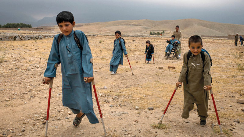 (من اليسار إلى اليمين) «بشير، منجل، مروة، عبدالرشيد (على كرسي متحرك)، أمان، وعلى مسافة (ربيع)» خلال ذهابهم إلى المدرسة.  من المصدر