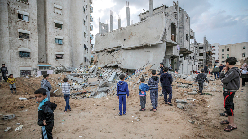 فتيان فلسطينيون يمرون قبالة المباني التي تهدمت جراء القصف الإسرائيلي في الهجوم الأخير على غزة. إي.بي.إيه