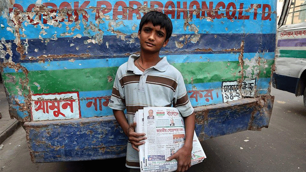 شاب في مقتبل العمر يعمل ببيع الصحف، بنغلادش