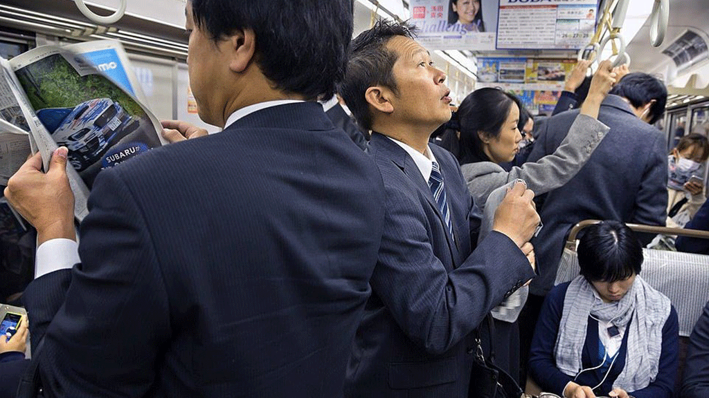 صباح في الميترو برفقة الصحف والهواتف المحمولة لتمضية الوقت، اليابان