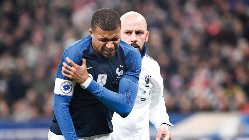 مبابي ممسكاً بكتفه بعد الإصابة.  أ.ف.ب