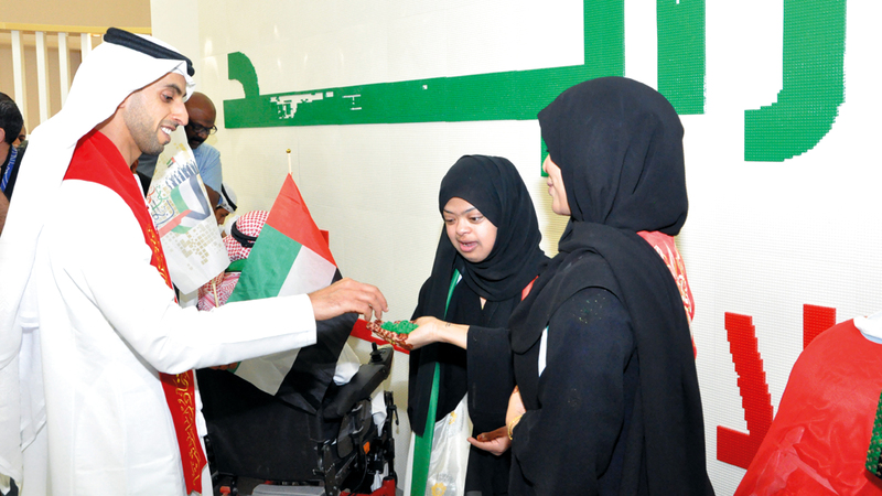 خالد بن زايد يشارك أصحاب الهمم في وضع قطع «الليغو» لأكبر جدارية باسم «زايد». من المصدر