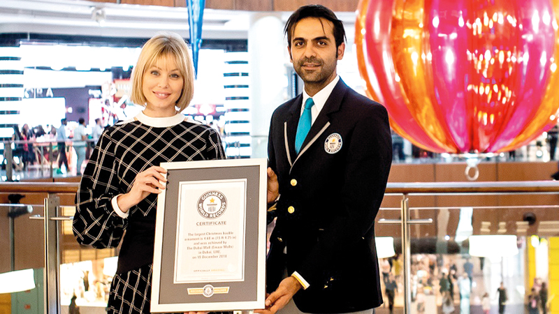 ممثل «غينيس» يقدم الشهادة الرسمية إلى مديرة «دبي مول» ربيكا جيكوب. من المصدر