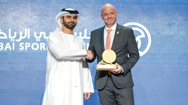منصور بن محمد خلال تكريمه رئيس «فيفا» إنفانتينو  في مؤتمر دبي الرياضي. الإمارات اليوم