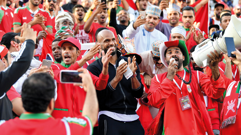 علي الحبسي وسط الجماهير العمانية خلال تشجيع منتخب بلده أمس.  تصوير: نجيب محمد