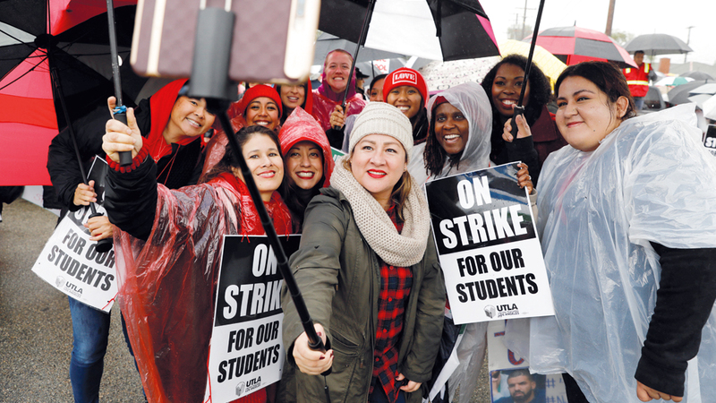 أولياء أمور يرفعون لافتة كتب عليها «لا إضراب من أجل أطفالنا».  رويترز