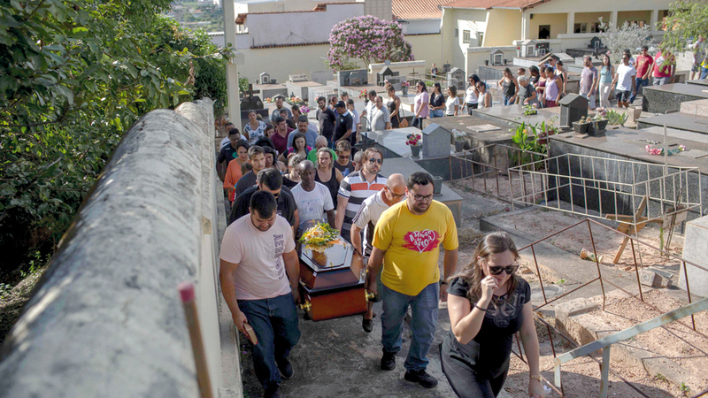 ذوو الضحايا يحملون جثامينهم إلى المقبرة.  أ.ف.ب