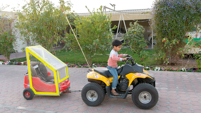 الأب صنع لـ «خالد» عربة آمنة مرتبطة بدراجة أخيه عمر.

تصوير: أحمد عرديتي