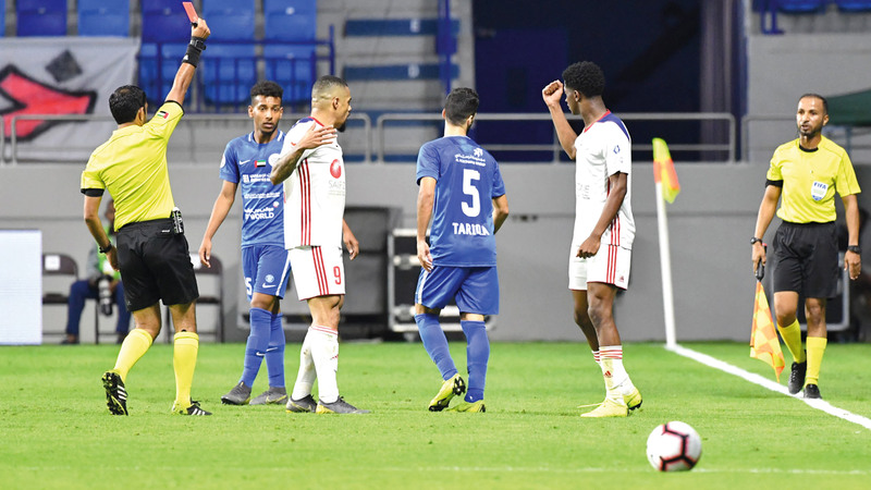 الحكم محمد عبدالله حسن يخرج الورقة الحمراء للاعب النصر طارق أحمد.  تصوير: أسامة أبوغانم
