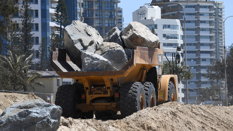 جرافة تقوم بعملية بناء صخري للحد من أثر هيجان الأمواج المحتمل في كوينزلاند.  إي.بي.إيه