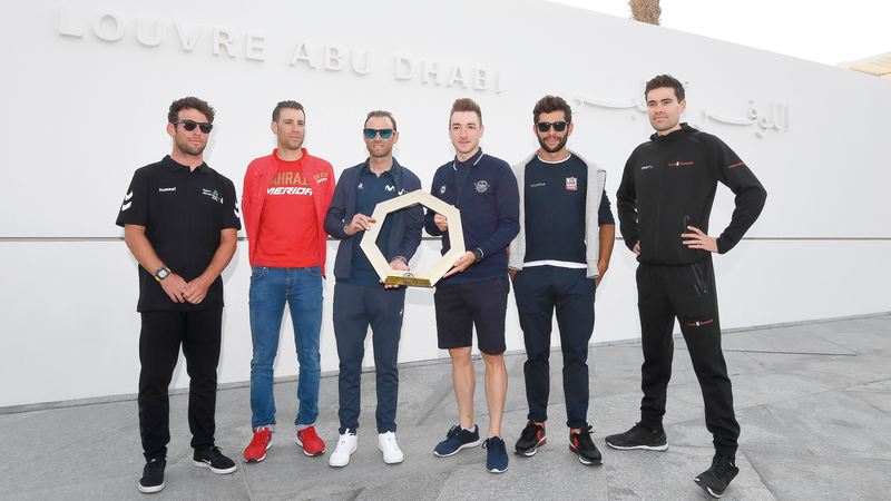 نخبة من أفضل الدراجين في العالم خلال صورة تذكارية بمتحف اللوفر بأبوظبي أمس. تصوير: إريك أرازاس
