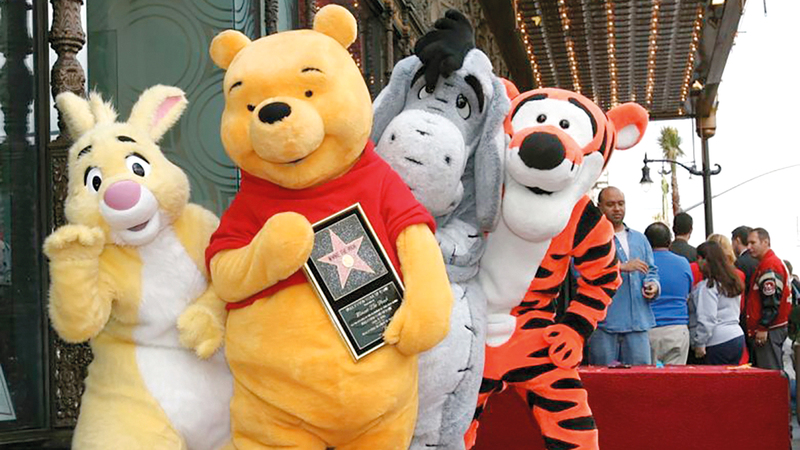 ويني ذي بوه (في الأمام) يتلقى نجمة في ممشى المشاهير في هوليوود.  أرشيفية، أ.ف.ب
