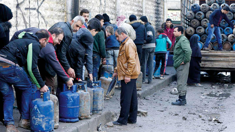 الناس في مدينة حلب يصطفون في طوابير من أجل الحصول على أسطوانات الغاز الشحيحة.  غيتي