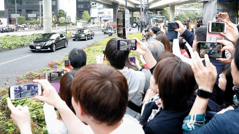 يابانيون يحاولون التقاط الصور للإمبراطور الجديد.  أ.ب