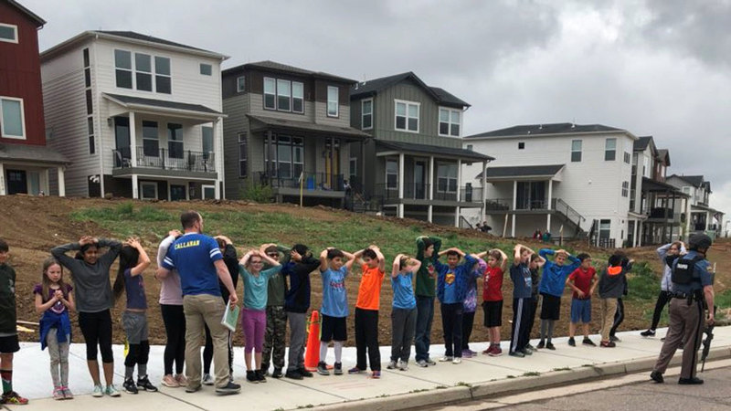 الأطفال يصطفون في طابور خارج سور المدرسة بعد حادث إطلاق النار.  رويترز