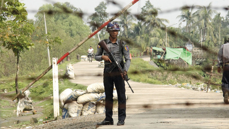 أحد ضباط شرطة ميانمار يقف في حراسة نقطة تفتيش شمال راخين.  أ.ب