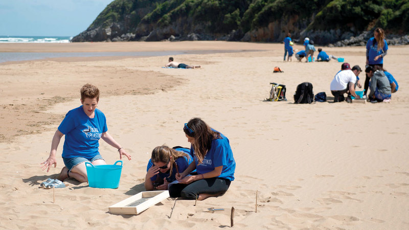 متطوعون يجمعون النفايات البلاستيكية من مياه البحر بالقرب  من قرية باسكو الإسبانية.  أ.ف.ب