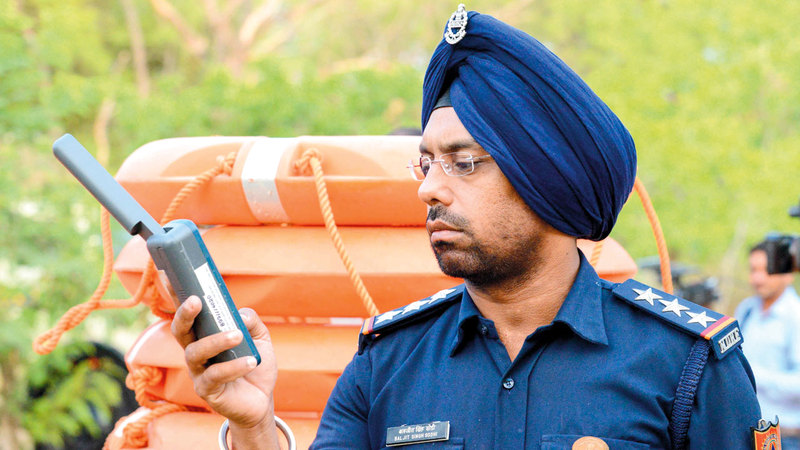 المفتش باجيت سينغ يتابع آخر مستجدات حركة الإعصار عن طريق هاتف متصل بالقمر الاصطناعي.  أ.ف.ب