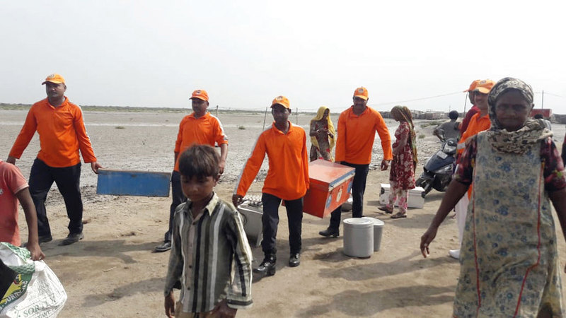 رجال الإنقاذ يحملون ما أمكنهم من أمتعة القرويين.  أ.ب