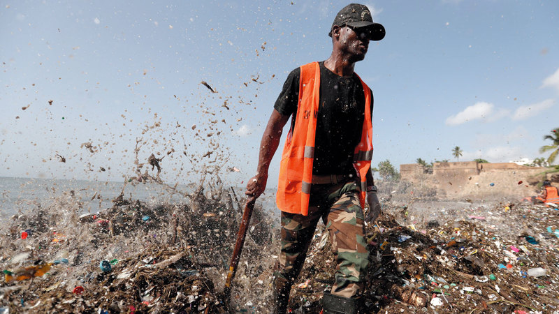 رجل يسير على شاطئ ملوث بالنفايات البلاستيكية  في جمهورية الدومنيكان.  رويترز