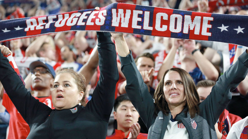 أميركيون يحملون لافتات ترحب باللاجئين.  أ.ف.ب