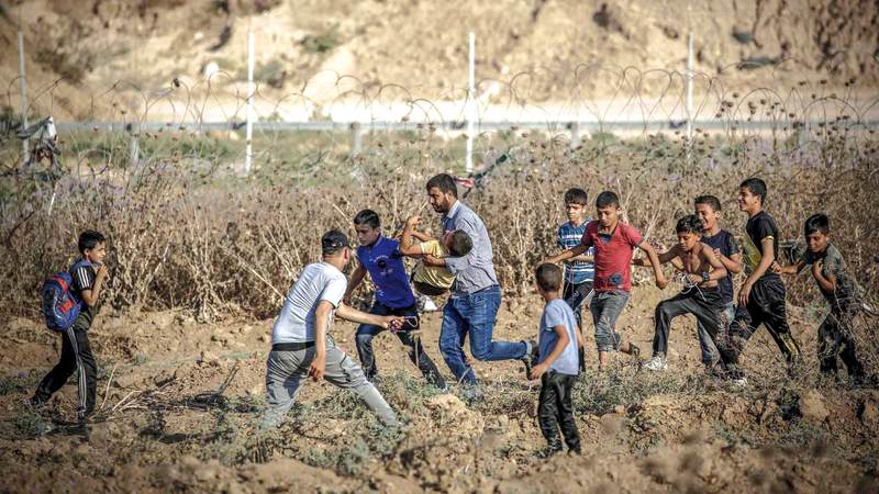 فلسطينيون يجلون أحد الجرحى في قطاع غزة بعد اشتباكات مع الجنود الإسرائيليين عبر حدود القطاع. أ.ف.ب