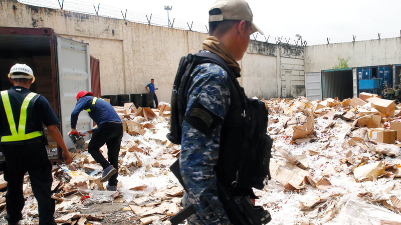 جندي يراقب موقع سجائر مقلدة تم تدميرها كجزء من محاربة الفساد. أ.ب