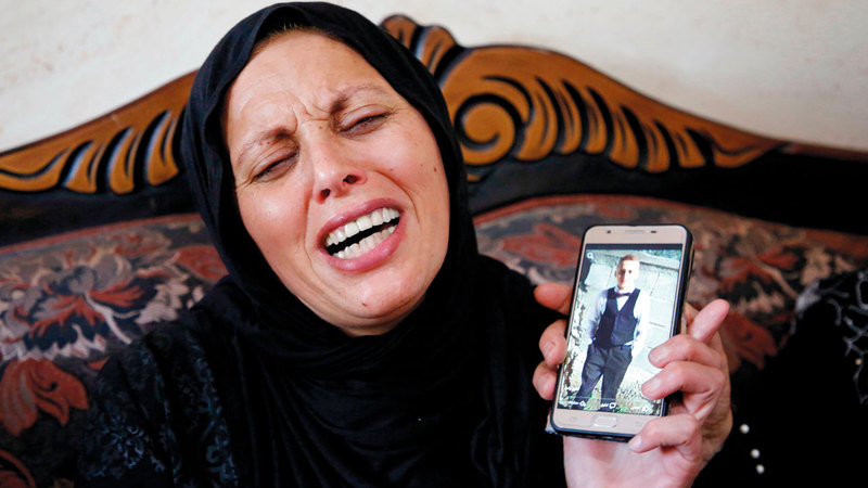 والدة الشهيد الصبي  نسيم أبورومي تنتحب وهي تحمل صورة له.  أ.ب
