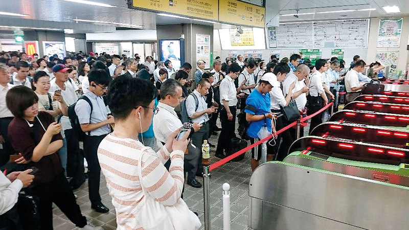 ركاب ينتظرون عودة خدمة القطارات بعد انقطاعها في طوكيو.

أ.ب