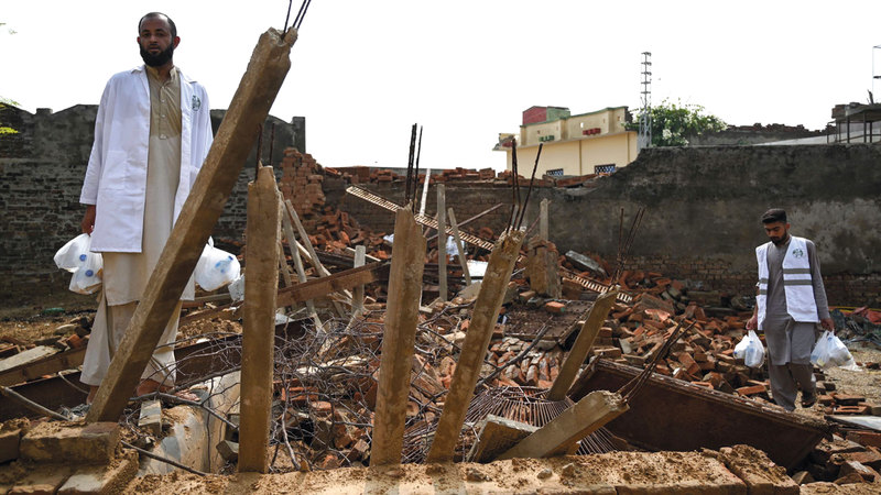 متطوع يحمل زجاجات مياه للناجين من الزلزال. أ.ف.ب