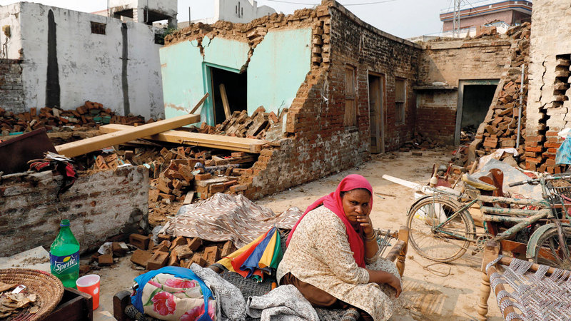 امرأة تجلس وسط حطام منزلها. رويترز