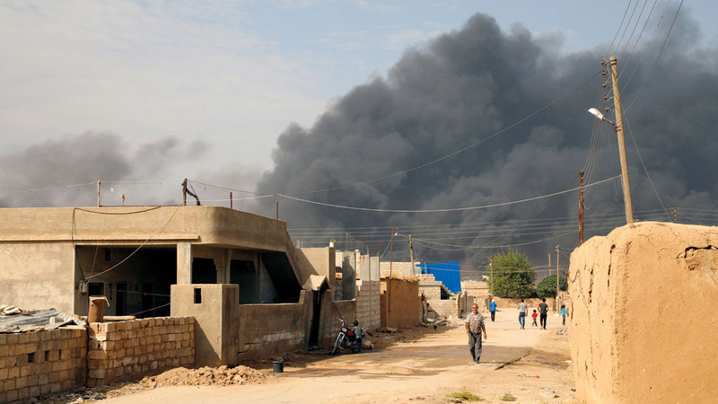 الدخان يتصاعد نتيجة الاشتباكات بين القوات التركية وقوات سورية الديمقراطية بالقرب  من مدينة رأس العين الحدودية. إي.بي.إيه