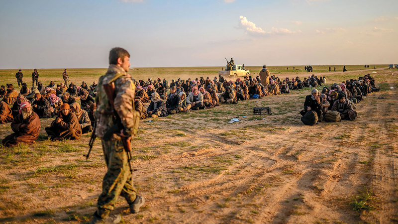 مقاتل كردي يحرس سجناء من عناصر «داعش». أ.ف.ب