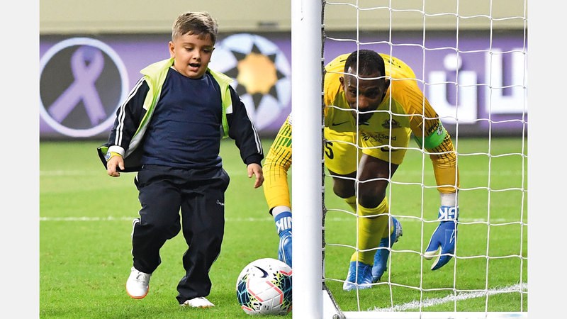 الطفل محمد قيس يسدّد الكرة في شباك ماجد ناصر. تصوير: أسامة أبوغانم
