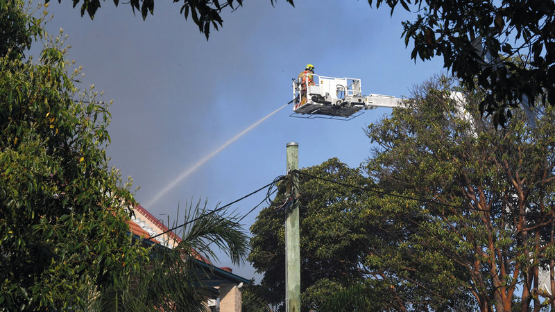 رجل إطفاء على متن رافعة يشارك في إطفاء الحريق.  أ.ف.ب