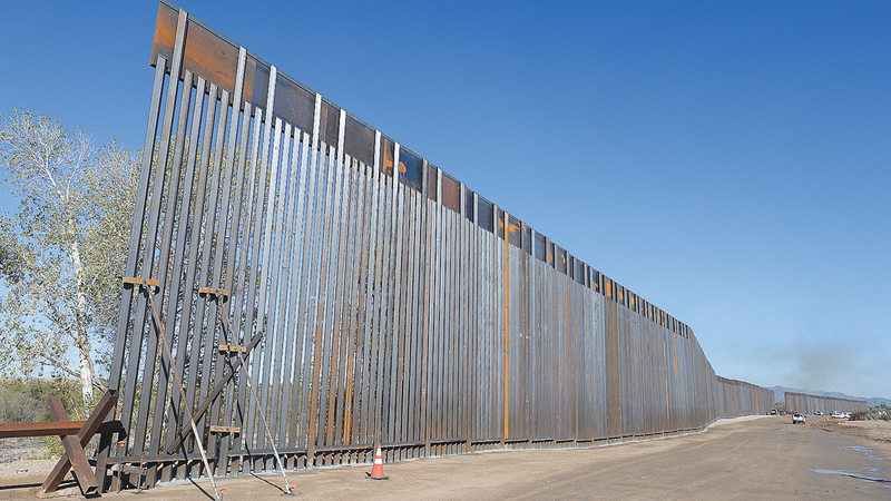 Work continues on the new 30-foot-high, bollard wall along the U.S.-Mexico border on the Colorado River near County 11th Street, Friday, Nov. 1, 2019. When the project is complete, the new wall will stretch for five miles along the border.(Randy Hoeft/The Yuma Sun via AP)
