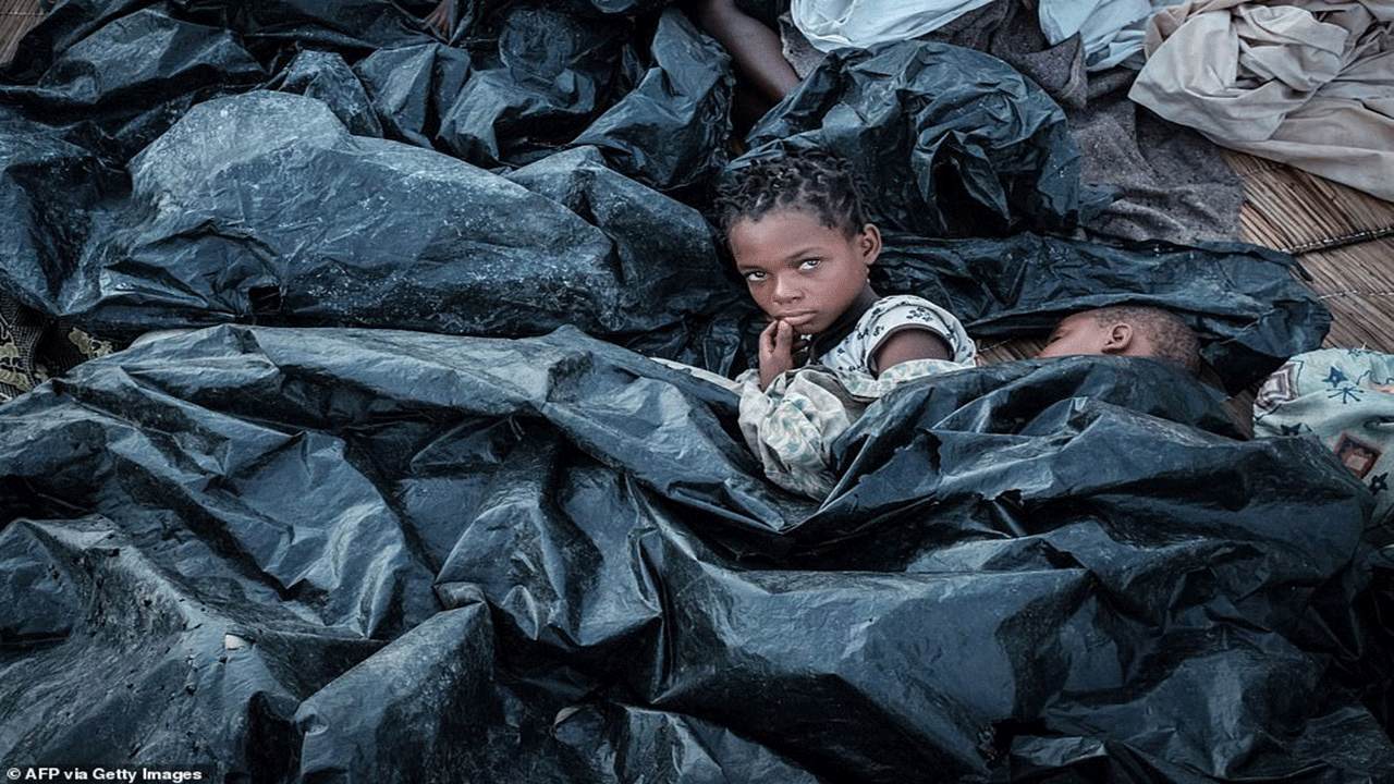 فتاة تحتمي من المطر بأغطية من الأكياس البلاستيكية في الموزمبيق.