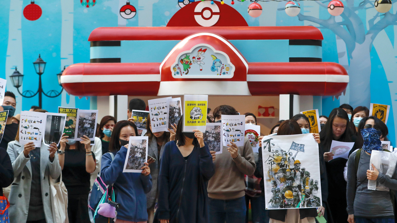 موظفون ومتظاهرون يحملون اللافتات المؤيدة للديمقراطية وحرية التعبير. أ.ب