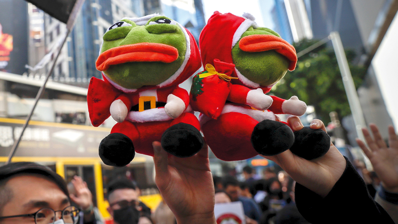 المتظاهرون يحملون دمى الضفادع للتعبير عن احتجاجهم في تظاهرة ضد الحكومة أمس. أ.ب