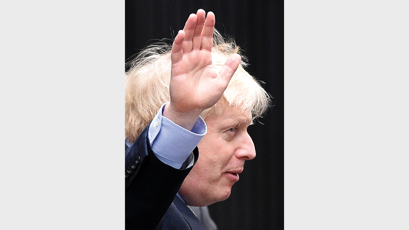 جونسون يلوّح بعد فوزه الكاسح في الانتخابات. رويترز