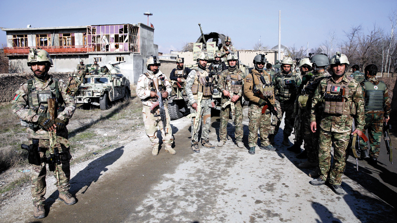 جنود أفغان يخفرون موقعاً انفجرت فيه سيارة بالقرب من قاعدة باغرام الأميركية في أفغانستان.  إي.بي.إيه